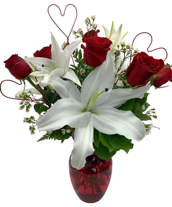 Red roses and white lilies in red vase with hearts and greenery