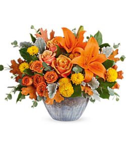 Golden fall glow of roses and lilies, arranged in a gorgeous keepsake oven-to-table ceramic bowl. It's finished with an eye-catching artisanal glaze in shades of steel blue.